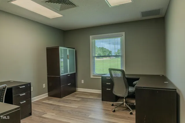 a view of a workspace with furniture and wooden floor