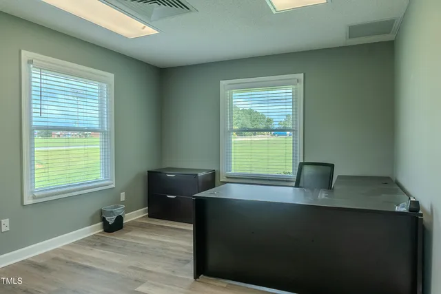 a view of a workspace with furniture and a window