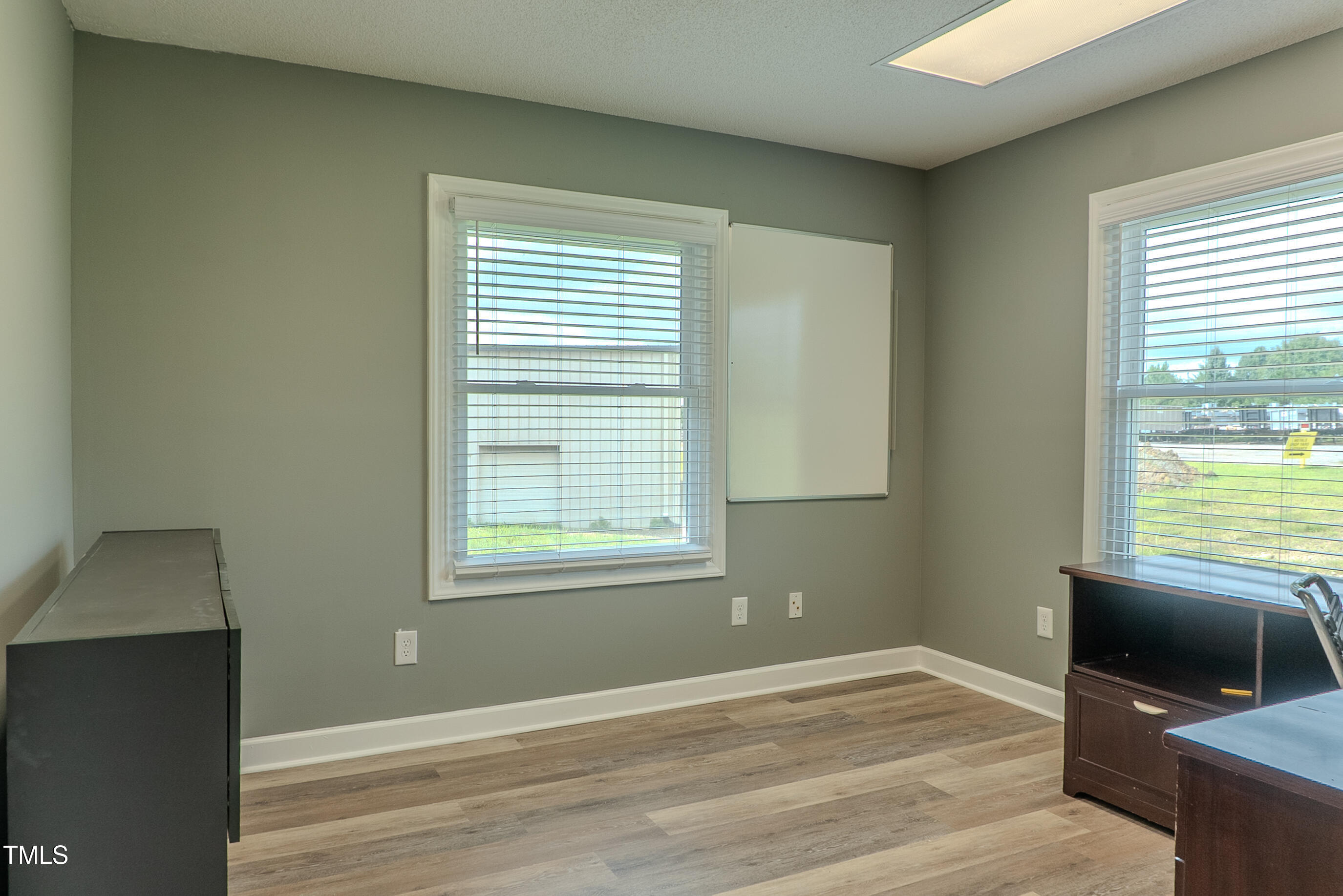 6504 Burlington Road Whitsett, NC 27377 - Photo 13 of 34 a view of an empty room with a window and wooden floor