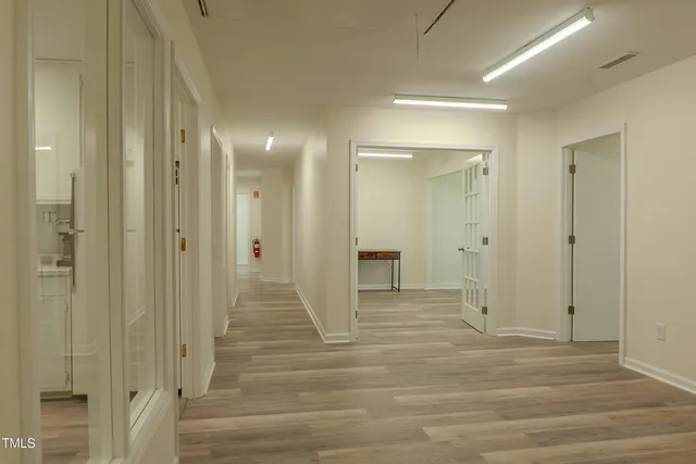 a view of a hallway with wooden floor and closet area