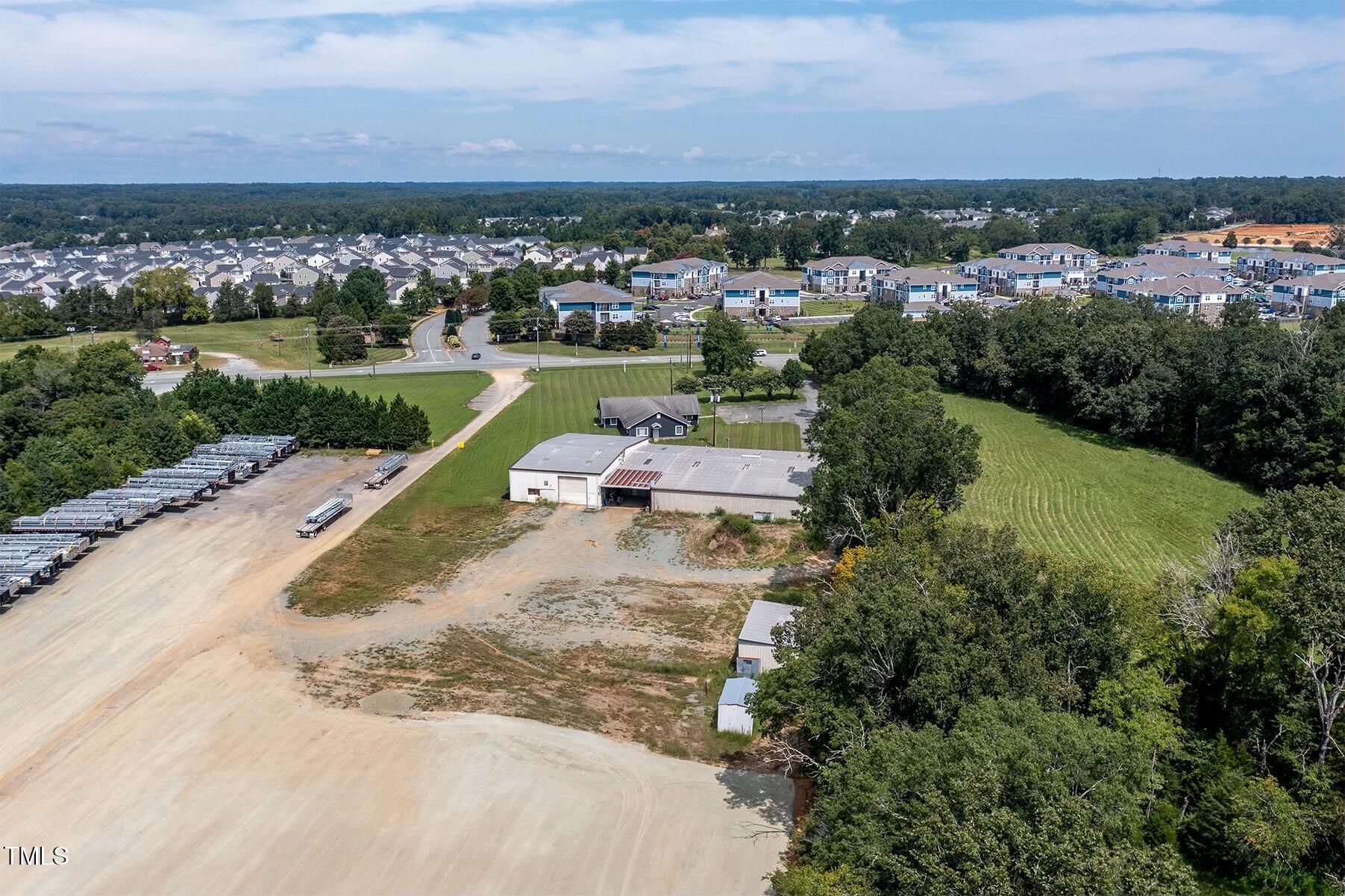 6504 Burlington Road Whitsett, NC 27377 - Photo 3 of 34 an aerial view of a house with a garden and lake view
