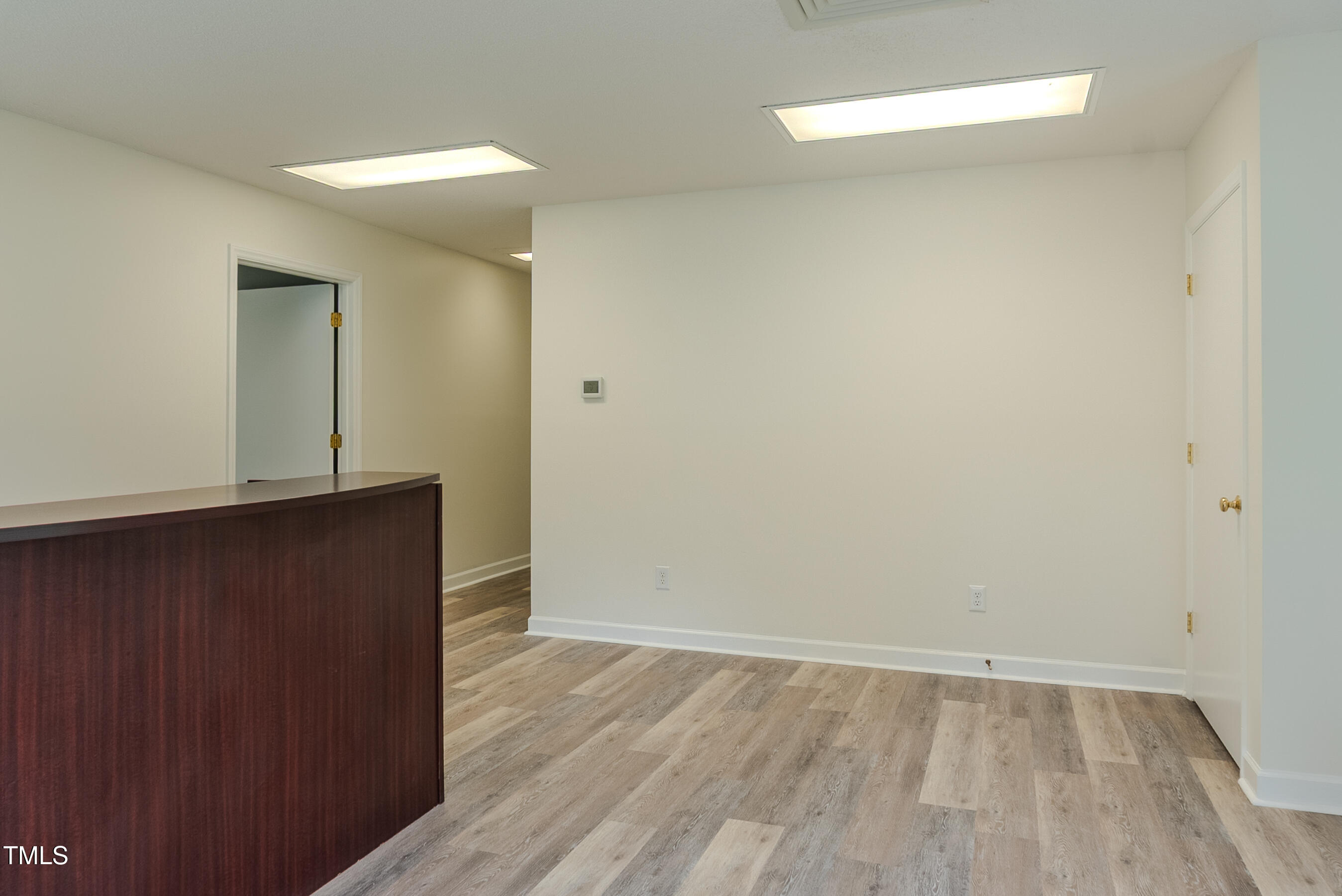 6504 Burlington Road Whitsett, NC 27377 - Photo 6 of 34 an empty room with wooden floor and windows
