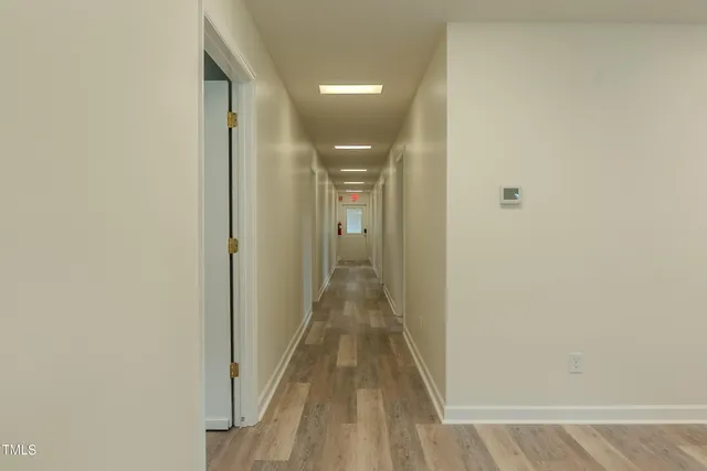 a view of a hallway with wooden floor