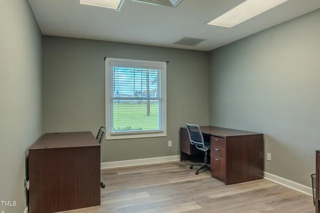 an empty room with wooden floor and a window