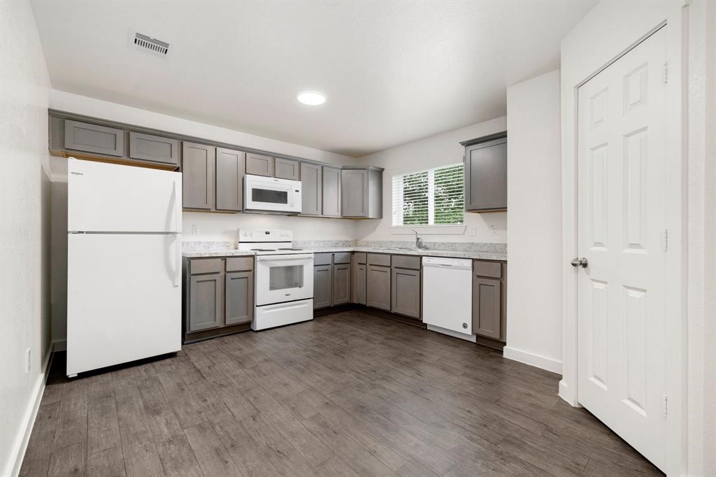 12603 Telge Road, Unit 32 AD Cypress, TX 77429 - Photo 8 of 13 a kitchen with a sink a refrigerator and a microwave