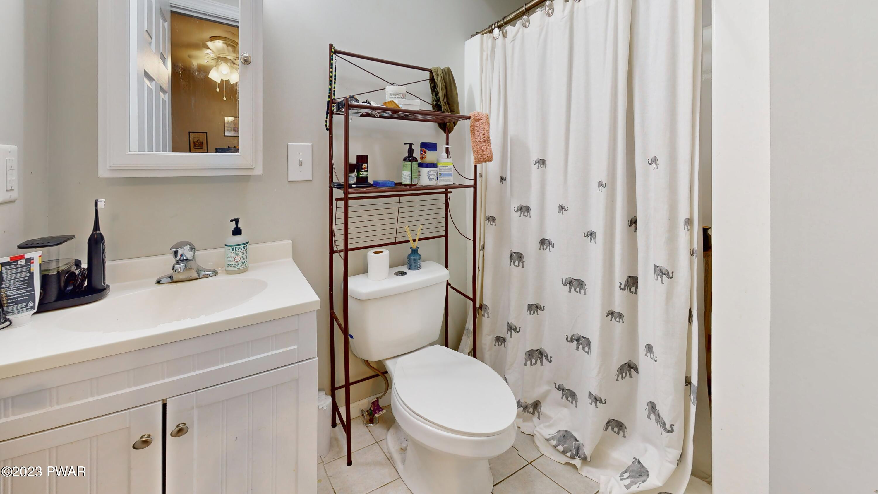 149 Walker Lake Road Shohola, PA 18458 - Photo 23 of 51 a bathroom with a sink a toilet and shower curtain