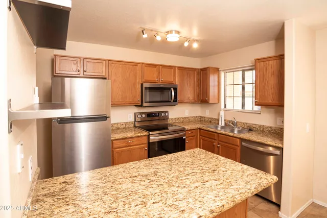 a kitchen with granite countertop stainless steel appliances and wooden cabinets