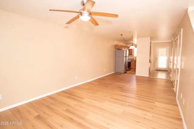 a view of a big room with wooden floor and a ceiling fan