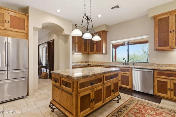 a kitchen with stainless steel appliances granite countertop a stove a sink a refrigerator and a microwave