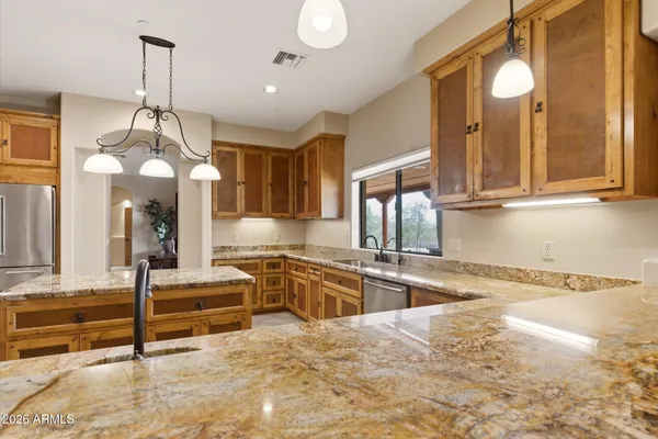 a view of a kitchen with granite countertop a sink stainless steel appliances and cabinets