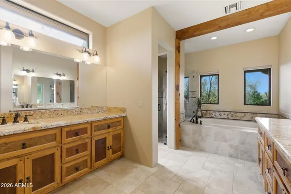 a spacious bathroom with a granite countertop sink mirror and bathtub