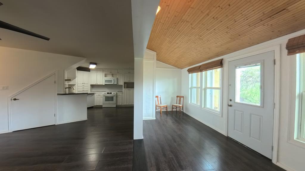 929 Red Bluff Road Pipe Creek, TX 78063 - Photo 8 of 29 a view of an empty room and kitchen with wooden floor