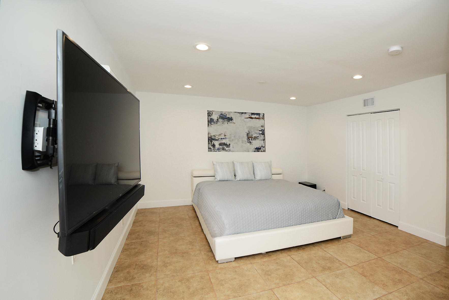 200 Southwest 2nd Street Boca Raton, FL 33432 - Photo 14 of 26 a spacious bedroom with a bed and a flat screen tv