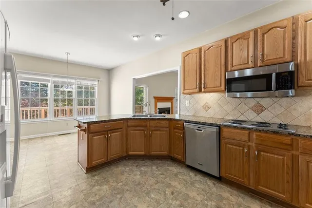 a kitchen with stainless steel appliances granite countertop a refrigerator and a sink