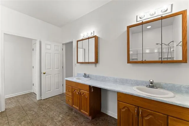 an empty room with windows and chandelier fan