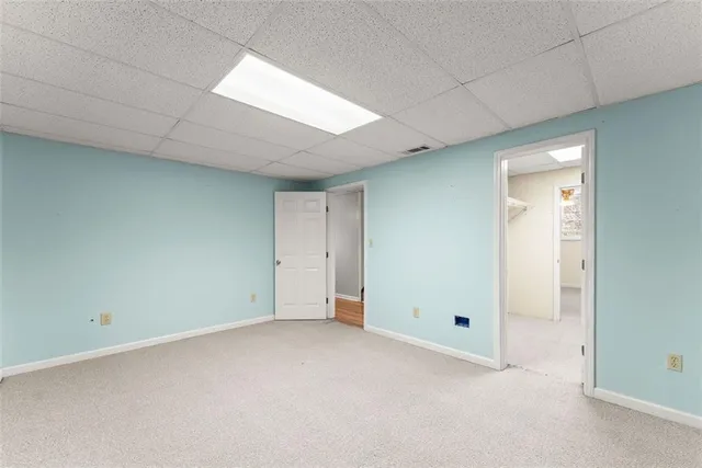 an empty room with windows and cabinet