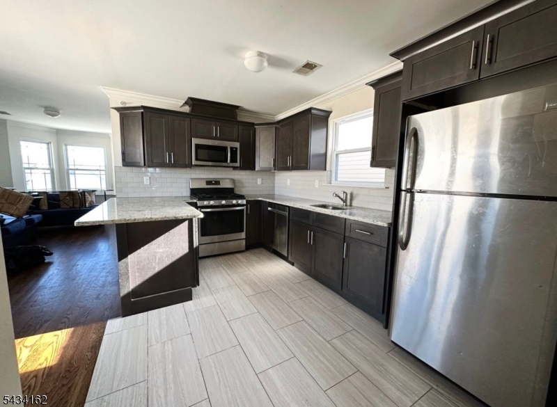25 Amity Street, Unit 2 Elizabeth, NJ 07202 - Photo 1 of 3 a kitchen with stainless steel appliances granite countertop a refrigerator a stove a sink and a microwave