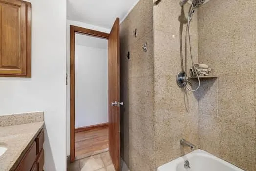 a bathroom with a granite countertop shower and a sink