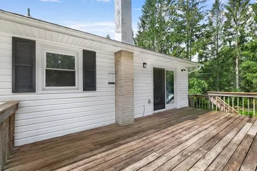 a view of a house with a big yard and large trees