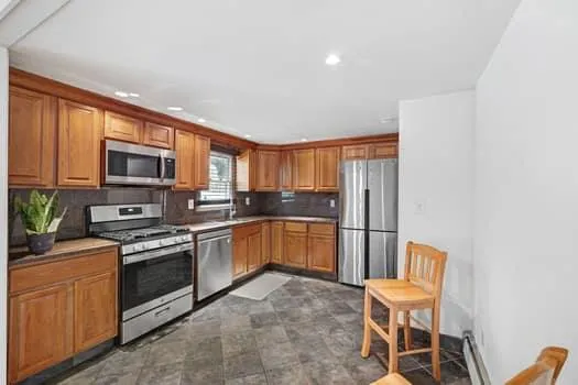 a kitchen with stainless steel appliances granite countertop a stove a sink dishwasher a microwave oven with a dining table and chairs