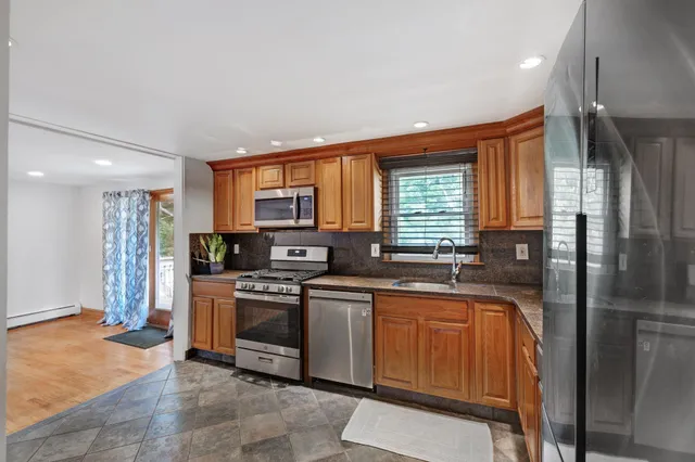 a kitchen with stainless steel appliances granite countertop a refrigerator a sink a stove top oven a sink and dishwasher