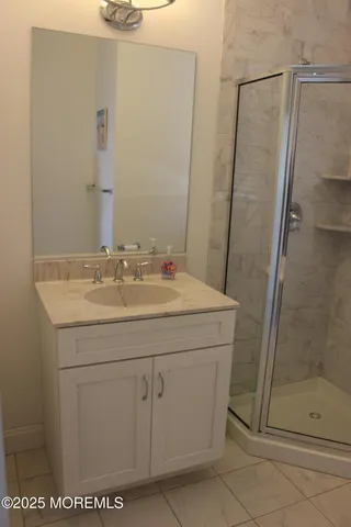 a bathroom with a shower sink and vanity