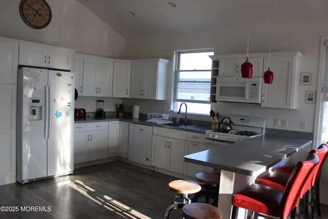 a kitchen with a refrigerator and white cabinets