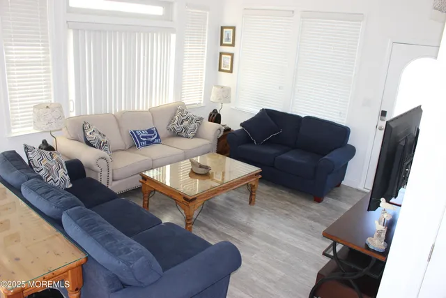 a living room with furniture a wooden floor and a large window