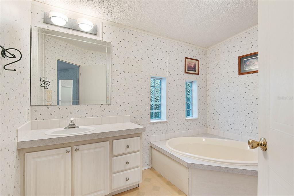 4544 Butternut Avenue Bunnell, FL 32110 - Photo 13 of 42 a bathroom with a tub a sink and mirror