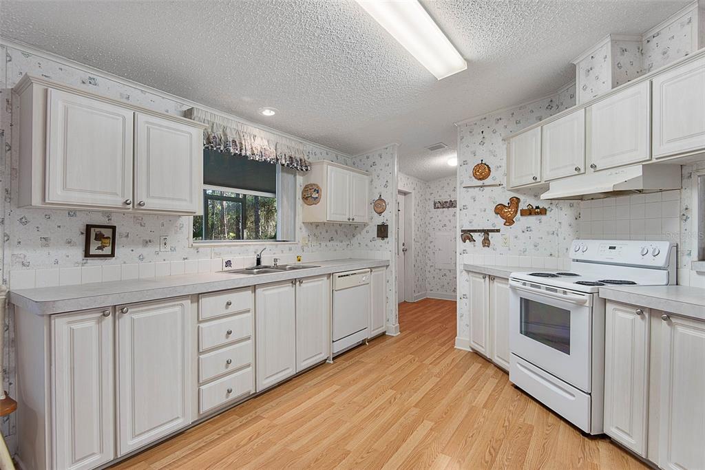 4544 Butternut Avenue Bunnell, FL 32110 - Photo 22 of 42 a kitchen with granite countertop white cabinets and white appliances
