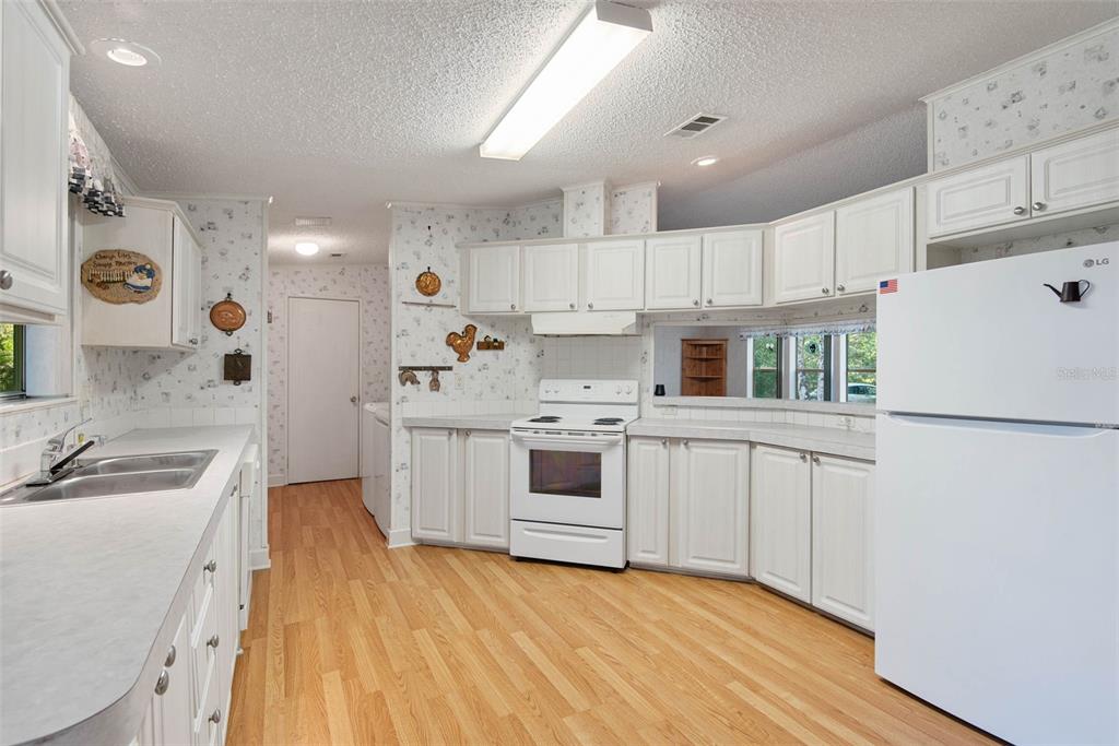4544 Butternut Avenue Bunnell, FL 32110 - Photo 23 of 42 a kitchen with a sink a stove a refrigerator and white cabinets