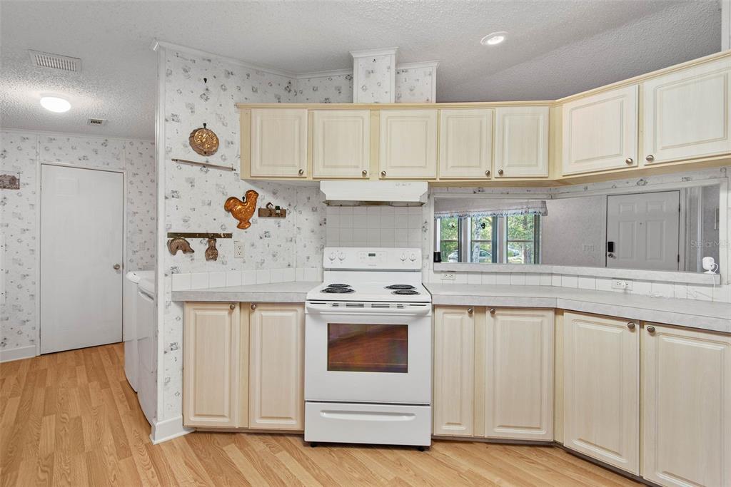 4544 Butternut Avenue Bunnell, FL 32110 - Photo 24 of 42 a kitchen with stainless steel appliances granite countertop a white stove top oven and white cabinets