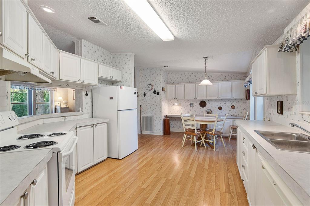 4544 Butternut Avenue Bunnell, FL 32110 - Photo 25 of 42 a kitchen with white cabinets and white appliances