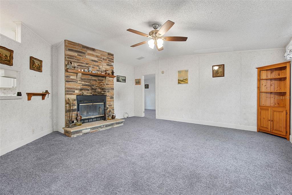 4544 Butternut Avenue Bunnell, FL 32110 - Photo 6 of 42 a view of an empty room with a fireplace and a window