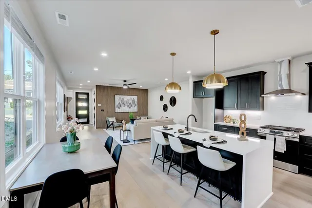 a kitchen with a sink a stove and chairs with wooden floor