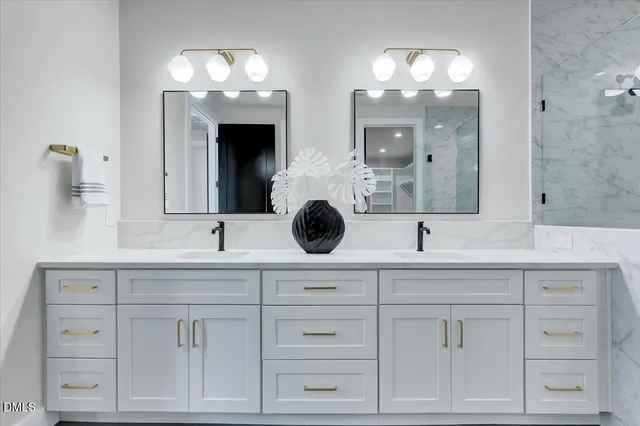 a bathroom with a double vanity sink mirror and shower