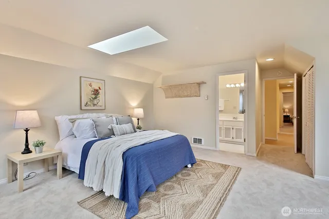 a spacious bedroom with a bed and a lamp