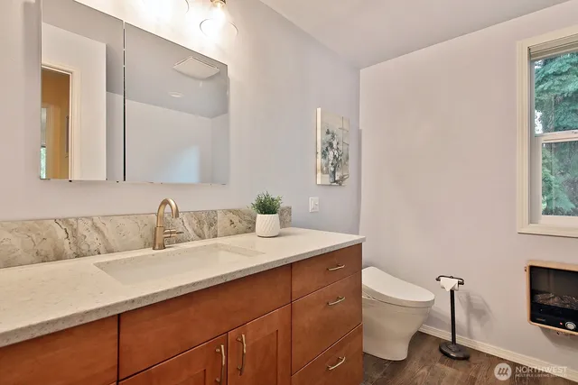 a bathroom with a toilet sink and mirror