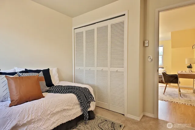 a bedroom with a bed and a chair with the wooden floor