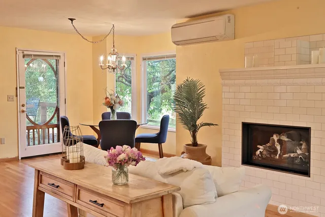 a living room with furniture a fireplace and a floor to ceiling window