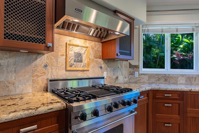 a kitchen with stainless steel appliances kitchen island granite countertop a table and chairs in it