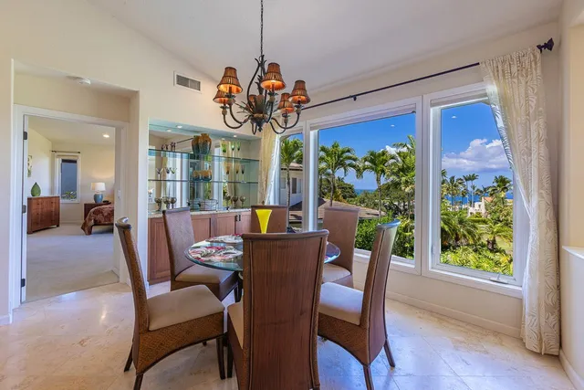 a kitchen with stainless steel appliances kitchen island granite countertop a table and chairs