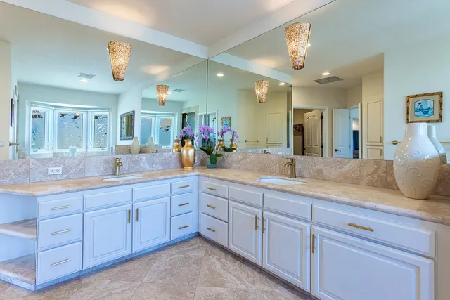 a spacious bathroom with a granite countertop sink a large mirror and shower