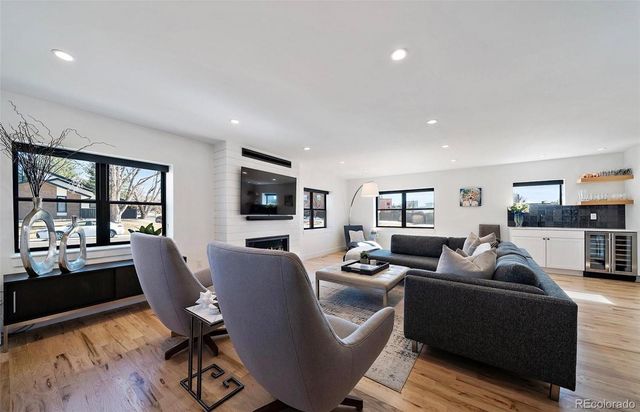a living room with furniture flat screen tv and a large window