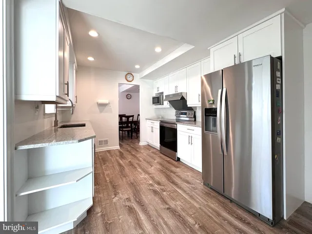 a kitchen with stainless steel appliances a refrigerator and cabinets