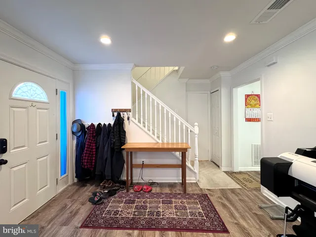 a view of entryway and hall with wooden floor