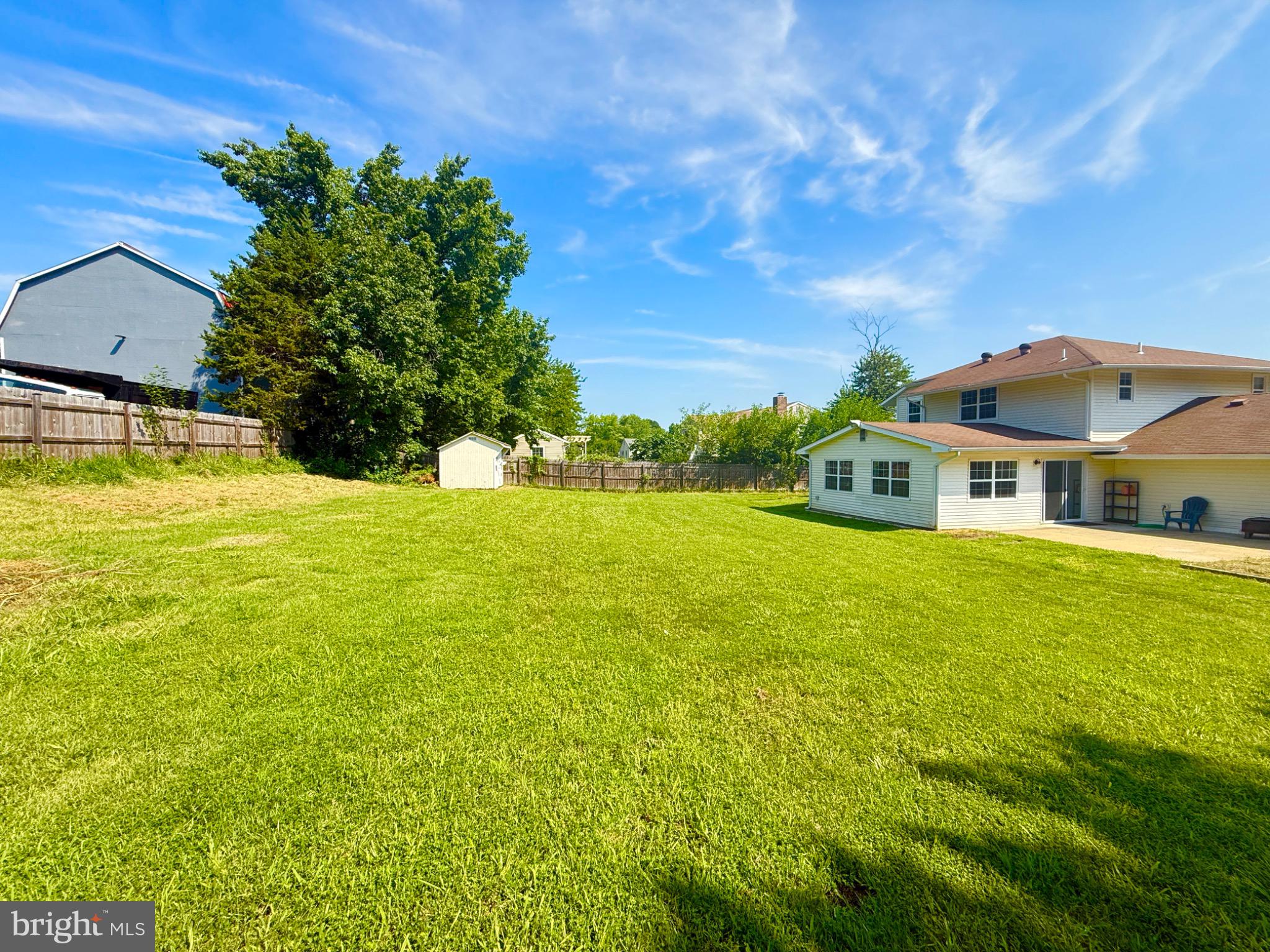 Spacious backyard with lush green lawn.