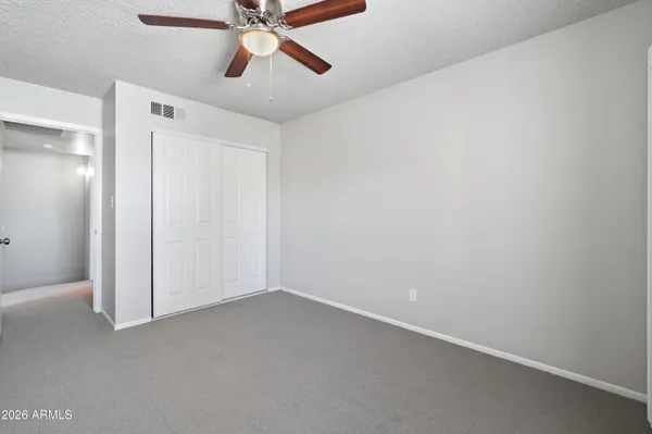 an empty room with a window and a ceiling fan