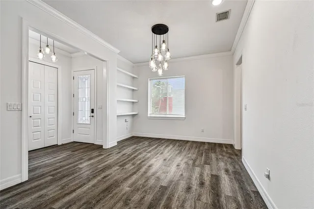 a kitchen with stainless steel appliances kitchen island granite countertop a table chairs sink and cabinets