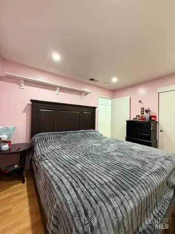 a bed sitting in a spacious bedroom next to a window